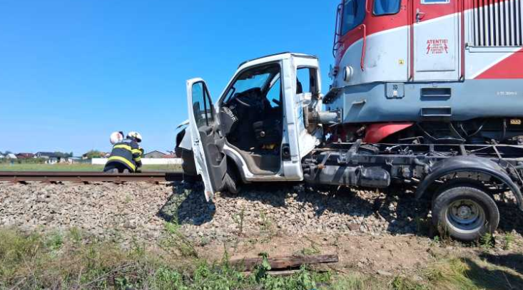 Impact violent între un tren și o autoutilitară! Șoferul a fost aruncat din vehicul. Pompierii au intervenit de urgență