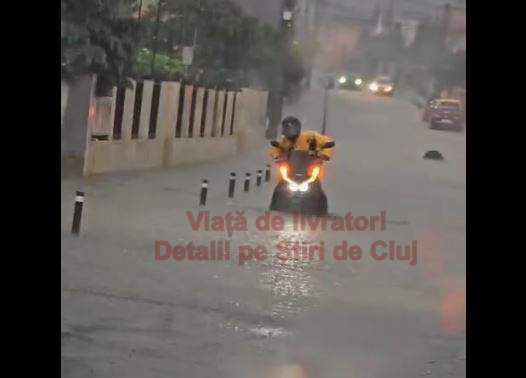 VIDEO. Grea e viața de livrator la Cluj! Își împinge scuterul prin apă până la genunchi, pe unde nici mașinile nu trec, pentru a continua drumul